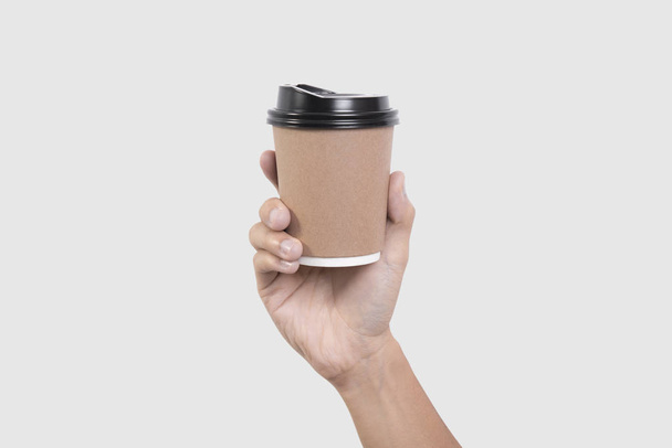 mão segurando copo de papel de café isolado no fundo cinza
.  - Foto, Imagem