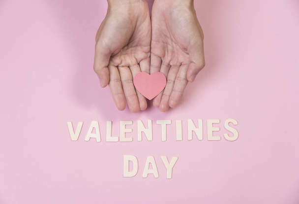 main tenant coeur rouge avec mot Saint Valentin sur rose
 - Photo, image