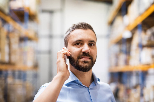 Warehouse worker or supervisor with a smartphone. - Foto, Bild