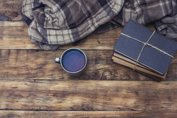Copo de metal com chá quente ou café, xadrez quente, uma pilha de livros Ti
 - Foto, Imagem
