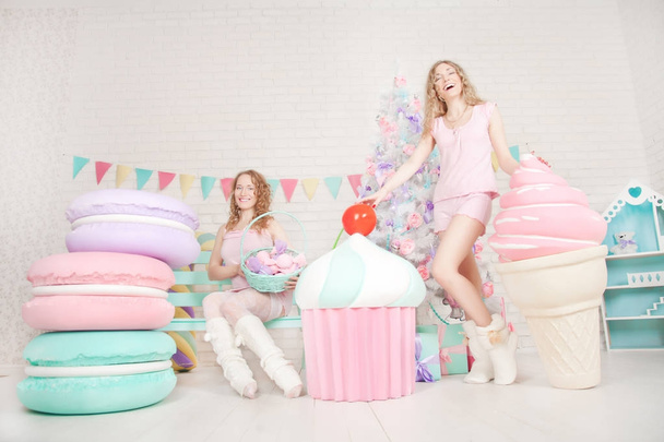 beautiful cute girls friends with giant yummy cake, macaroons and ice-cream on white background - Φωτογραφία, εικόνα