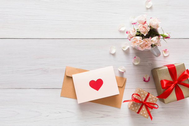 Fondo de San Valentín rosa flores ramo pétalos, cajas de regalo, tarjeta de felicitación hecha a mano con corazones en madera rústica blanca
 - Foto, imagen