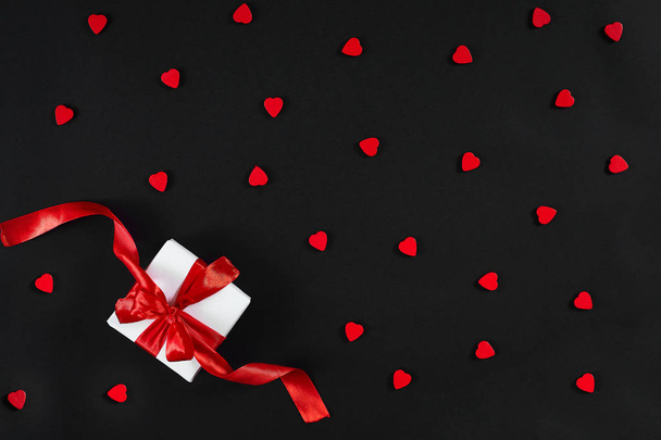 White gift box with red ribbon on black background. Valentines d - 写真・画像