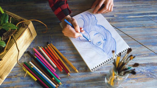 Close-up van vrouwelijke hand schilderij schets op papieren notitieblok met potloden. Vrouw kunstenaar op het werk - Foto, afbeelding