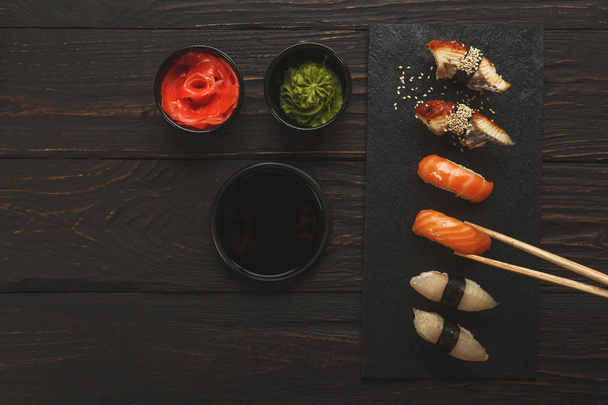 Set de sushi sobre fondo de madera negra, primer plano
 - Foto, Imagen