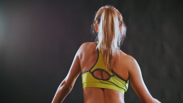 Nuori blondi houkutteleva nainen urheilupuvussa vahvistaa selkärangan lihaksia kuntoklubilla
 - Materiaali, video