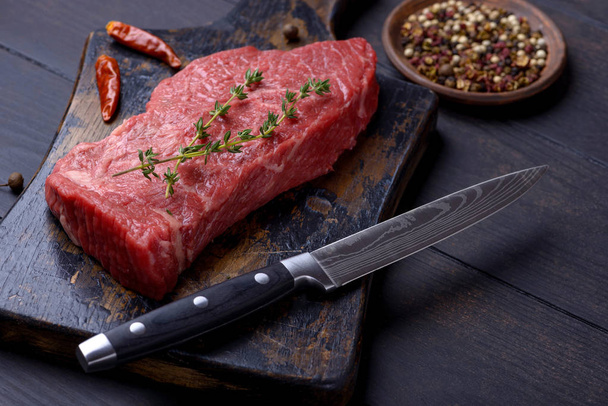 Raw steak with thyme and pepper and knife - Φωτογραφία, εικόνα