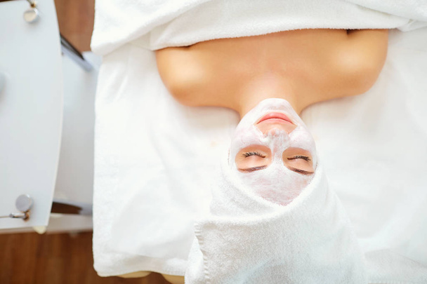 Woman in mask on face in spa salon. - Foto, immagini
