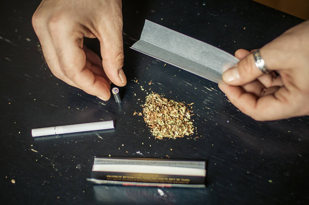 Preparing and rolling marijuana cannabis joint. Drugs narcotic c - Фото, зображення