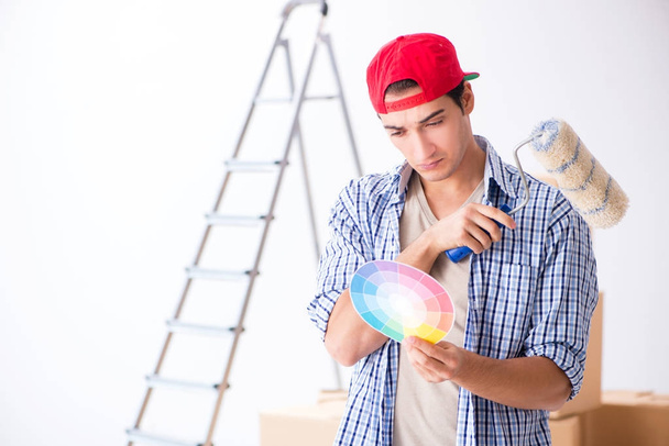 Joven contratista pintor eligiendo colores para la renovación del hogar - Foto, Imagen