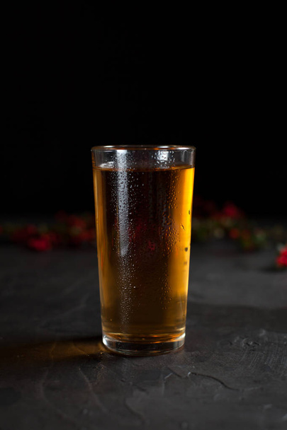 un bicchiere di succo d'uva fresco e un ramo con bacche rosse su fondo scuro
 - Foto, immagini