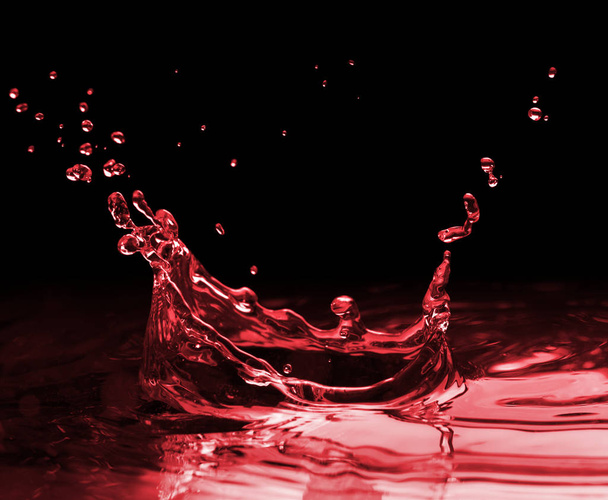 Red splash on a black - Zdjęcie, obraz