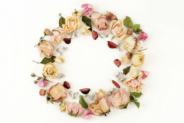 Flowers composition. Wreath made of dried roses flowers on white background. Flat lay, top view. copy space - Фото, зображення