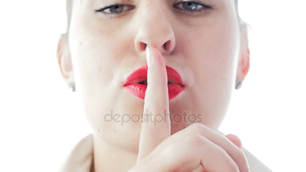 CLoseup повільні кадри руху сексуальна жінка жестикулює за мовчання або розповідає секрет. Вона піднімає палець на губи червоною помадою
 - Кадри, відео
