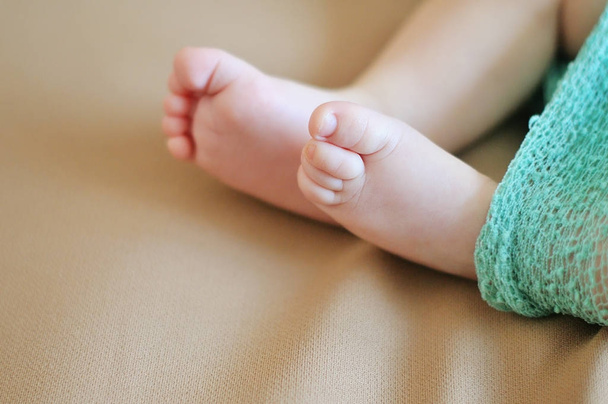 A close-up of tiny baby feet - Foto, afbeelding