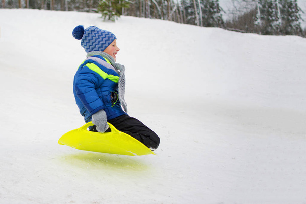 Dziecko leci w dół wzgórza płyta do jazdy na śniegu - Zdjęcie, obraz
