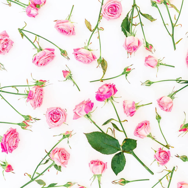 Bloemmotief met roze rozen, takken en bladeren op een witte achtergrond. Plat lag, Top uitzicht. Dag van de vrouw. - Foto, afbeelding