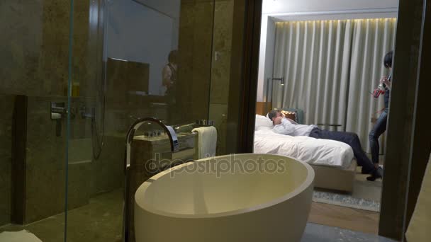 couple, homme d'affaires et femme brune aux cheveux courts en pantalon en cuir et ceinture épée utiliser un fouet et menottes à des fins sexuelles sur le lit dans une chambre d'hôtel. 4k
 - Séquence, vidéo