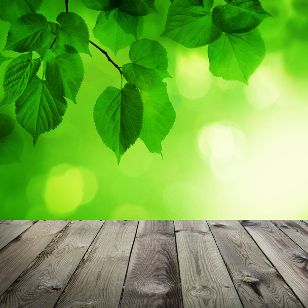 abstrakter Frühlingshintergrund mit leerem Holztisch, grünem Bokeh  - Foto, Bild