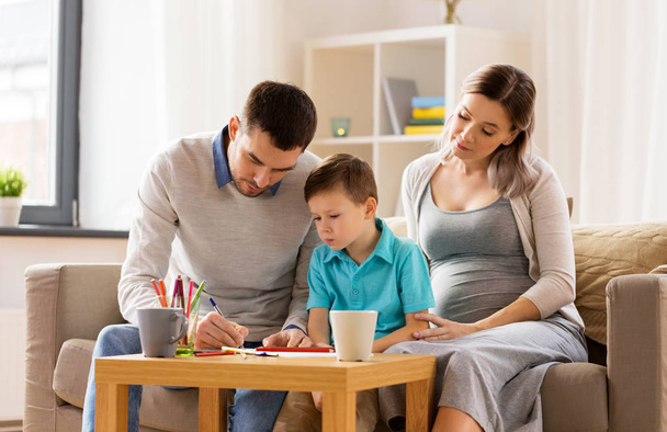 padre, madre embarazada e hijo dibujando en casa
 - Foto, Imagen
