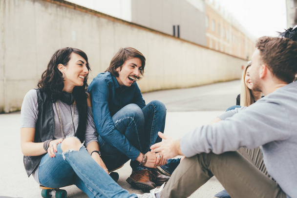 Gruppe von Freunden multiethnci sitzen draußen Spaß haben  - Foto, Bild
