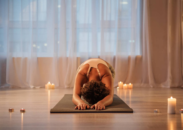 Serene girl exercising on mat with relaxation - Foto, afbeelding