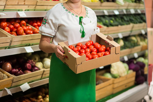 Frauenhände mit einer großen Kiste Tomatenernte auf dem Markt - Foto, Bild