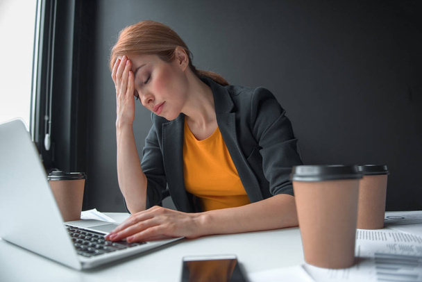 Tired businesswoman typing in laptop - Foto, Imagen