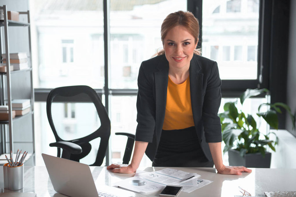 Cheerful businesswoman leaning on table - Photo, Image