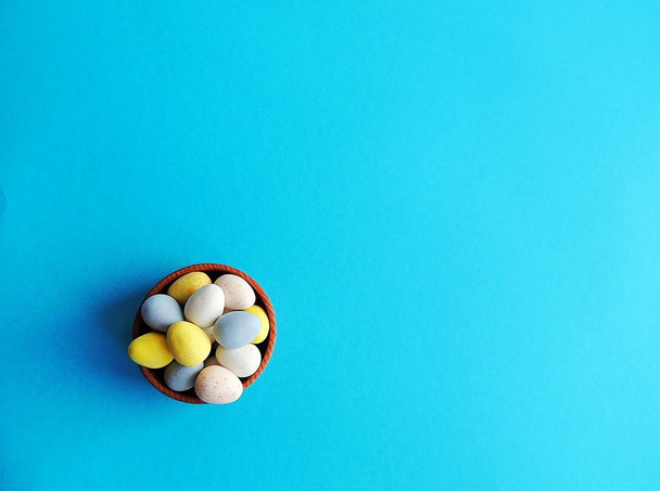 Huevos de chocolate de Pascua sobre fondo azul brillante. Diferentes colores
. - Foto, Imagen
