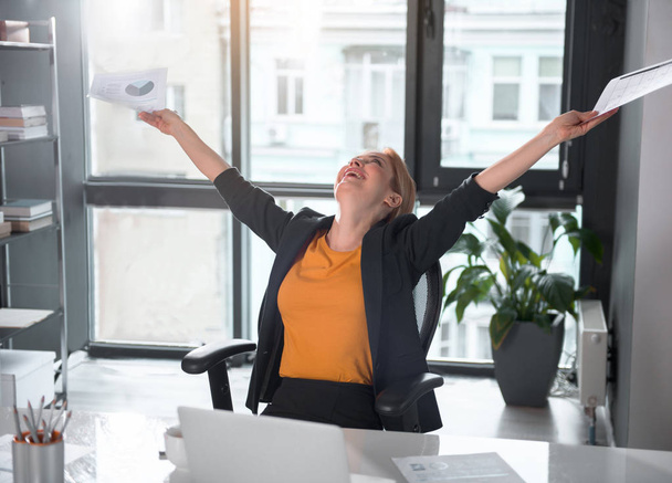 Outgoing businesswoman rising arms up - Photo, Image