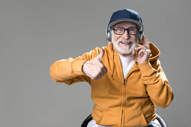 Pleased old man listening to lovely music - Foto, imagen