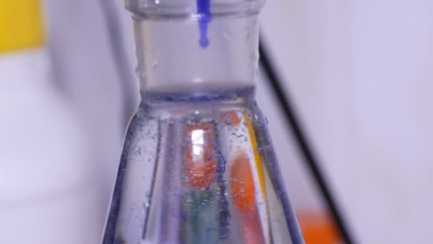 Míšení modrý roztok v baňce na laboratorní - Záběry, video