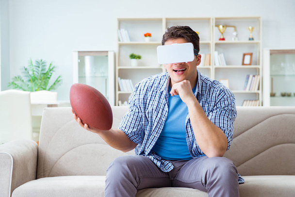 Mężczyzna w okularach VR wirtualnej rzeczywistości ogląda amerykańską piłkę nożną - Zdjęcie, obraz