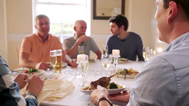 Los hombres están comiendo en una cena. Un hombre pasa su plato para que alguien le ponga un pedazo de comida.
.  - Metraje, vídeo