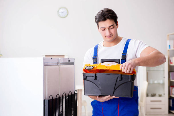 Reparateur aannemer repareert koelkast in DIY concept - Foto, afbeelding