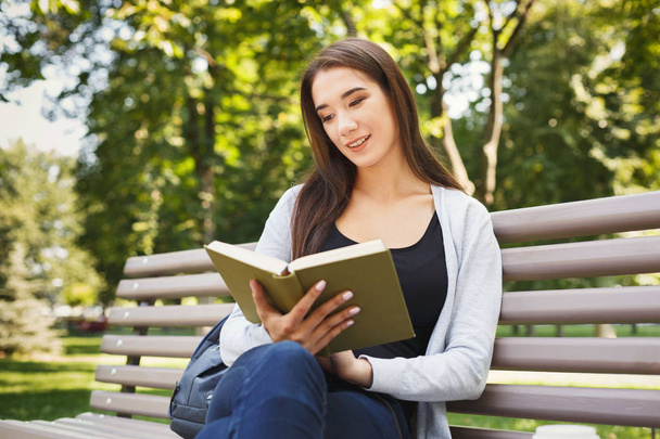 Νεαρή γυναίκα ανάγνωση βιβλίων στο χώρο του πάρκου αντίγραφο - Φωτογραφία, εικόνα