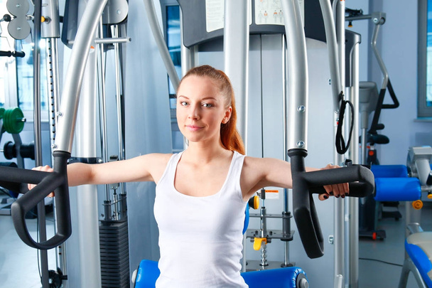 Beautiful girl at the gym exercising on trainers. Beautiful girl - Fotoğraf, Görsel