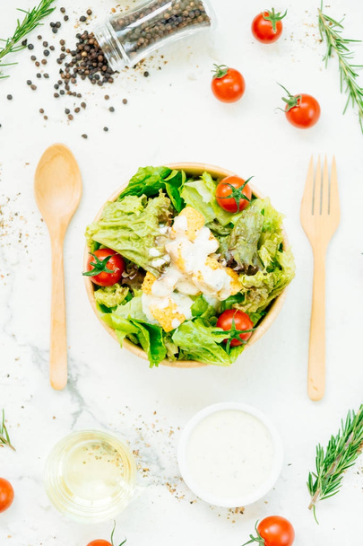 Style alimentaire propre et sain avec salade César dans un bol en bois
 - Photo, image