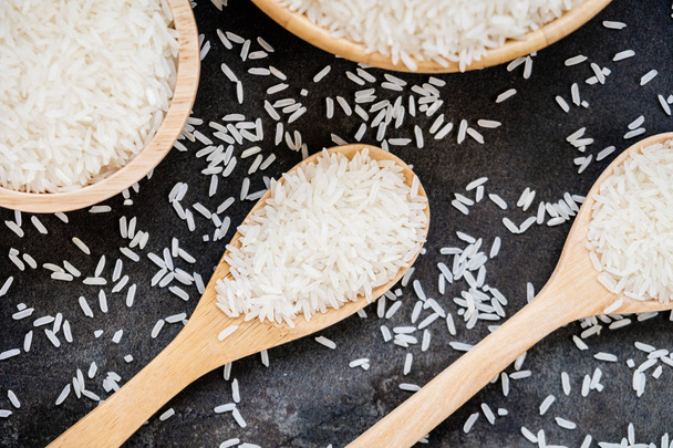 Raw Jasmine rice in wooden bowl  and spoon with grain and seed - Photo, Image