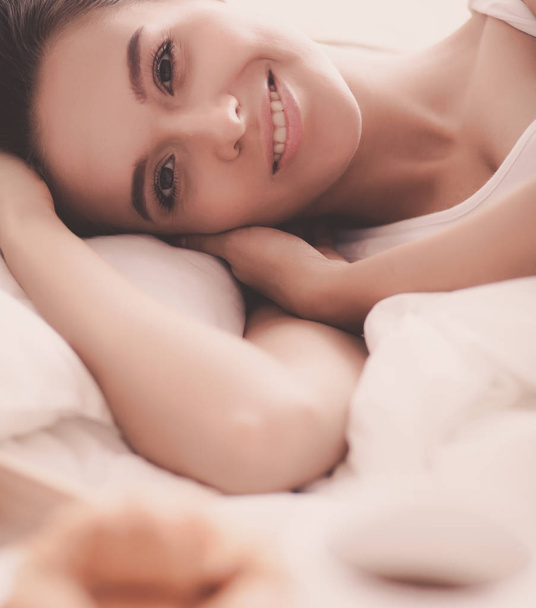 Young beautiful woman lying in bed at home - Фото, зображення