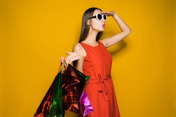 young stylish girl shopaholic in sunglasses looking afar and looking for discounts - Foto, imagen
