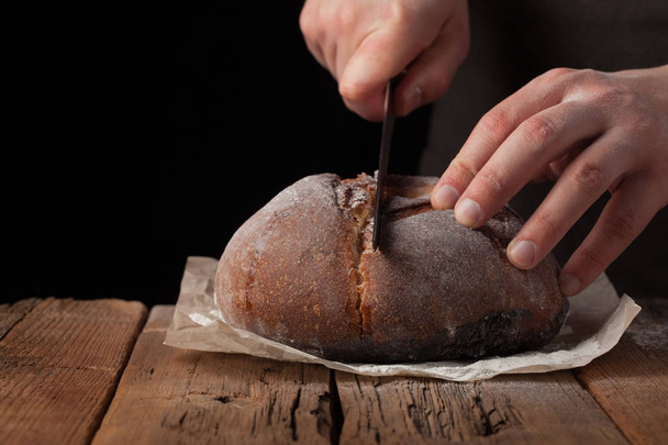 Adam kopya alanı metni siyah zemin üzerine lezzetli taze ekmek dilimleri. Eski rustik masada ekmek - Fotoğraf, Görsel