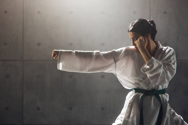 Nainen kimonossa harjoittelemassa karatea
 - Valokuva, kuva
