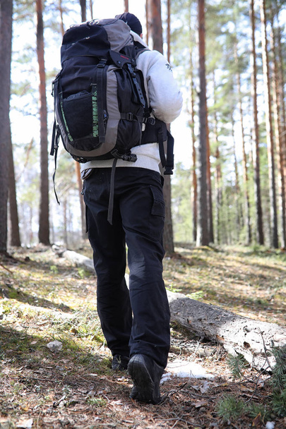 A man is a tourist in a pine forest with a backpack. A hiking tr - Foto, immagini
