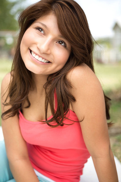 Молодая латиноамериканка, улыбающаяся снаружи
. - Фото, изображение
