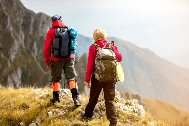 adventure, travel, tourism, hike and people concept - smiling couple walking with backpacks outdoors - Photo, Image