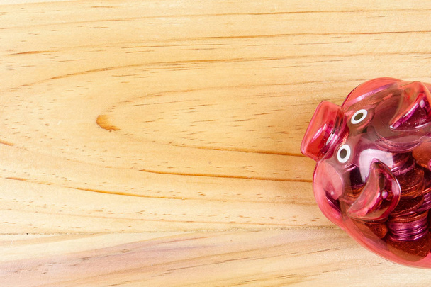 rotes Sparschwein und ein Glas mit Münzen auf dem Holztisch. Spar- und Anlagekonzept. - Foto, Bild