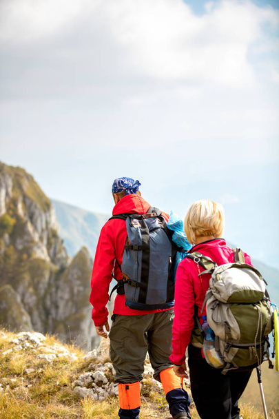Abenteuer, Reisen, Tourismus, Wandern und Menschen-Konzept - lächelndes Paar mit Rucksack im Freien - Foto, Bild