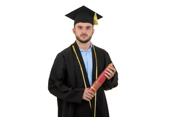cheerful smiling male graduate wearing gown and cap isolated on white - Foto, afbeelding